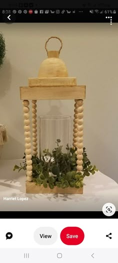 a wooden lantern with plants in it on a table