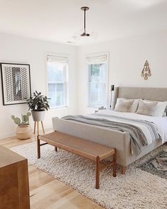 a bedroom with a bed, rugs and pictures on the wall above it's headboard