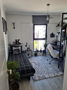 a bedroom with a bed, desk and shelves in it's center area next to a window