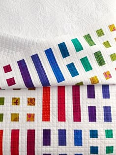 two quilts that have been made with different colored squares on them, one is white and the other is multicolored