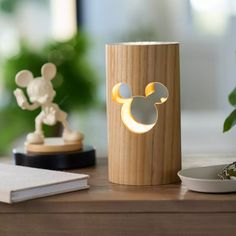 a mickey mouse lamp sitting on top of a wooden table