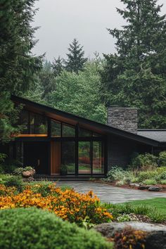 a modern house surrounded by trees and flowers