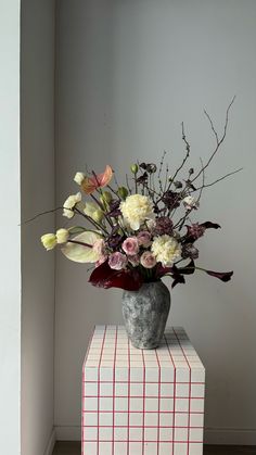 a vase filled with flowers sitting on top of a box