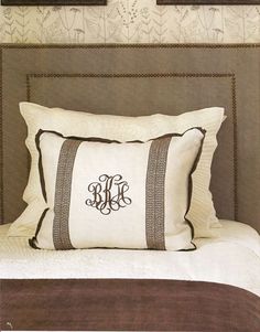 the monogrammed pillow is on top of the bed with two framed pictures above it