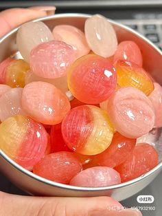 a person holding a metal bowl filled with jelly beans