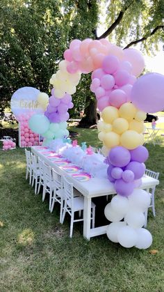 an outdoor party with balloons and tables