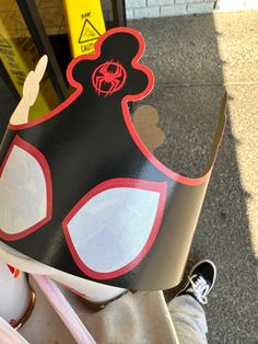 a person wearing a black and red paper crown on top of their head while riding a bike