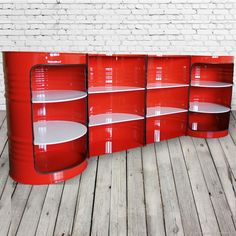 a red bookcase with white shelves on the bottom and one shelf below it, against a brick wall