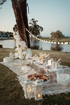 an outdoor table set up with food and candles