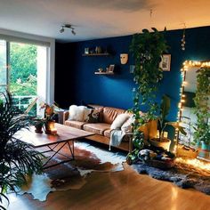 a living room filled with furniture and lots of plants