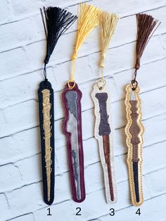 four different types of tassels hanging on a white brick wall with numbers in the bottom right corner