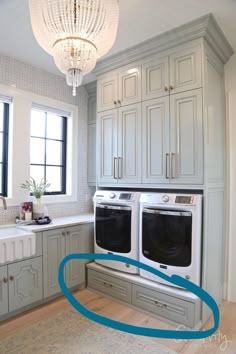 a kitchen with two washers in it and a chandelier hanging from the ceiling