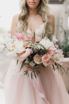 a woman holding a bouquet of flowers in her hand on the instagramr page