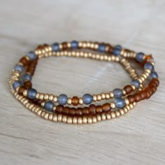 Handmade beaded bracelet stack, set of 3. Made with matte blue, brown and gold beads. Elastic stretch. Beaded Bracelet Stack, Fall Bead, Wood Bead Bracelet, Blue Beaded Bracelets, Brown Bracelet, Bracelets Design, Diy Bracelets Patterns, Beads Bracelet Design, Handmade Jewelry Tutorials