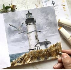 a drawing of a lighthouse with seagulls flying around it and watercolors on paper