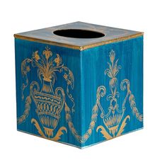 a blue box with gold designs on the front and sides, sitting against a white background