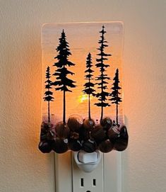 a light that is on the side of a wall with trees and rocks in it