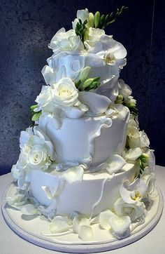 a wedding cake with white flowers on top