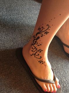 a woman's foot with a tattoo on it and an ankle strap around her ankles