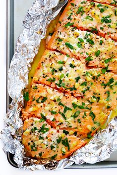 the salmon is covered in herbs and seasonings on top of tin foil, ready to be cooked