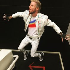 a man dressed in white is standing on a ramp with his arms out and hands outstretched