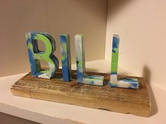 the letters are made out of wood and have blue and green paint on them,