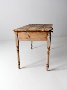 an old wooden table sitting on top of a white floor