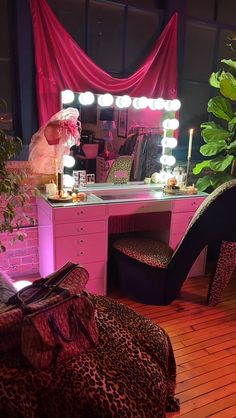 a leopard print chair sits in front of a vanity with lights on and a mirror