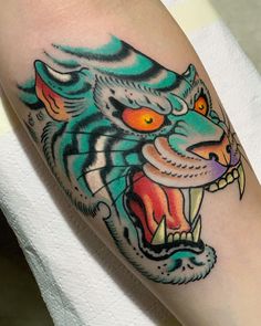 a colorful tiger tattoo on the arm