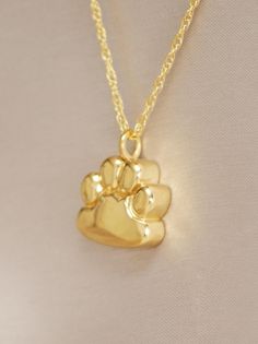 This paw print pendant is a unique way to hold a beloved pet close. This pendant can hold a small amount of cremains, lock of hair, or dirt from the sacred burial grounds. This piece comes on an 18" matching chain and 1/2 inch in size. GOOD TO KNOW: ♥ Available in Sterling Silver and 14K Plated Gold ♥THIS PENDANT CAN BE ENGRAVED-SEE PERSONALIZATION SECTION ♥Fill kit included with pendant CARE: ♥Both Sterling Silver and 14K Plated Gold are resistant to rust, corrosion, and tarnishing, but we stil Pet Memorial Jewelry Resin, Paw Print Pendant Necklace For Gift, Pet Hair Resin Pendant, Pet Ashes Jewelry, Paw Print Pendant, Pet Memorial Necklace, Pet Memorial Jewelry, Pet Cremation, Urn Jewelry