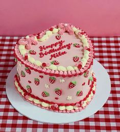 a heart shaped cake on a table with red and white checkered tablecloths