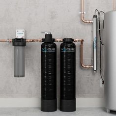 two water softeners in front of a wall