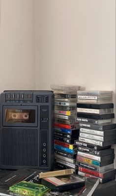 an old radio sitting on top of a table next to stacks of books and cds