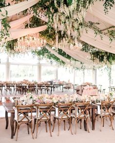 an instagram photo of a wedding venue with flowers and greenery hanging from the ceiling