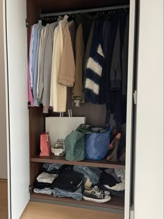 an open closet with clothes and shoes on it