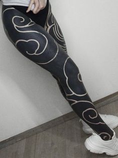 a woman in black and white patterned leggings with her hand on her hip