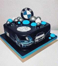 a bmw birthday cake with blue and silver decorations on the front, white and black background