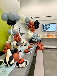 a long table with balloons and desserts on it