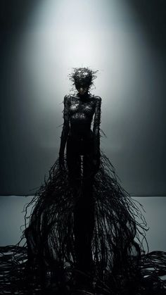 a woman is standing in the dark with branches on her head and hair all over her body