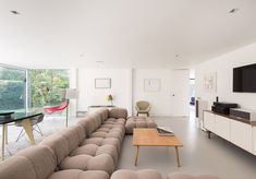 a living room filled with lots of furniture and a flat screen tv mounted on the wall