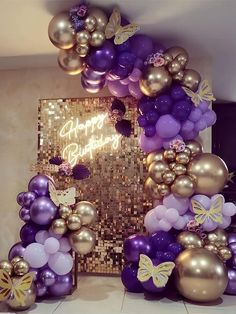 purple and gold balloons are arranged in the shape of a birthday arch with butterflies on it