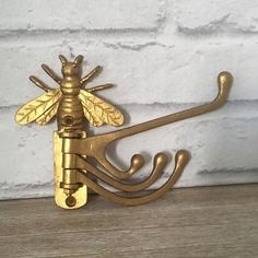 a gold metal hook with a bee on it