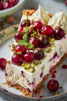 a piece of cheesecake with cherries and whipped cream on top is sitting on a plate