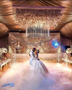 a bride and groom standing in front of a chandelier