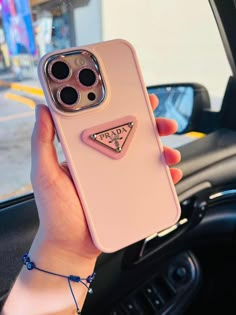 a person holding up a pink phone case