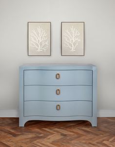 two paintings on the wall above a blue dresser