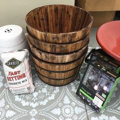 a wooden basket sitting next to a bucket and other items on top of a table