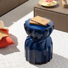 a blue vase sitting on top of a white rug next to a chair and table