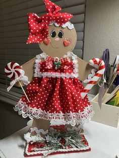 a gingerbread girl doll made out of paper on a table with candy canes