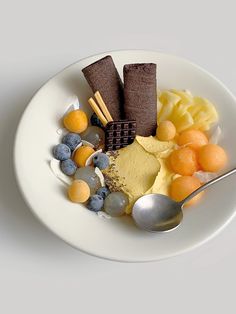 a white plate topped with different types of food and a spoon on top of it